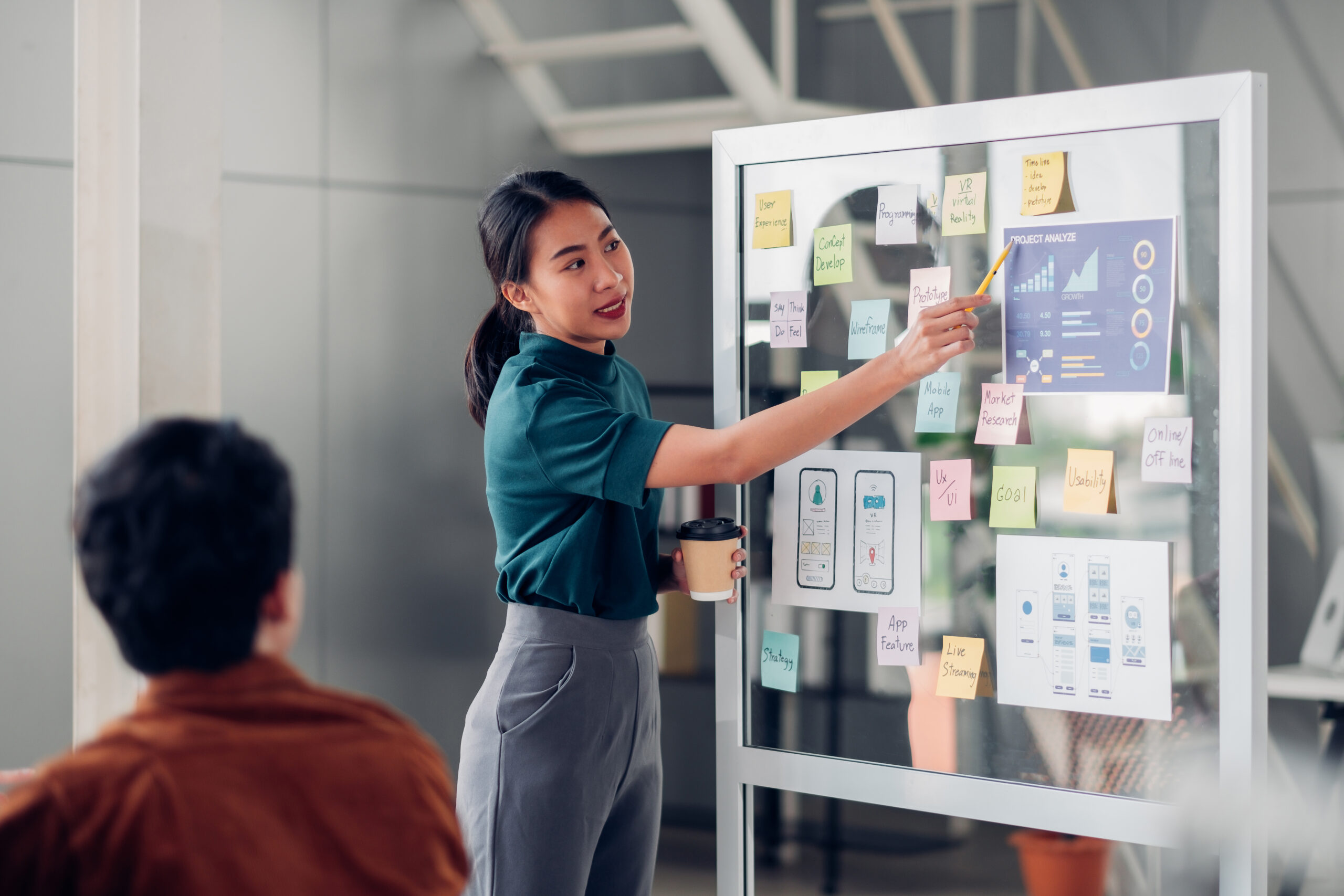 Asian,Ux,Developer,And,Ui,Designer,Presenting,Mobile,App,Interface